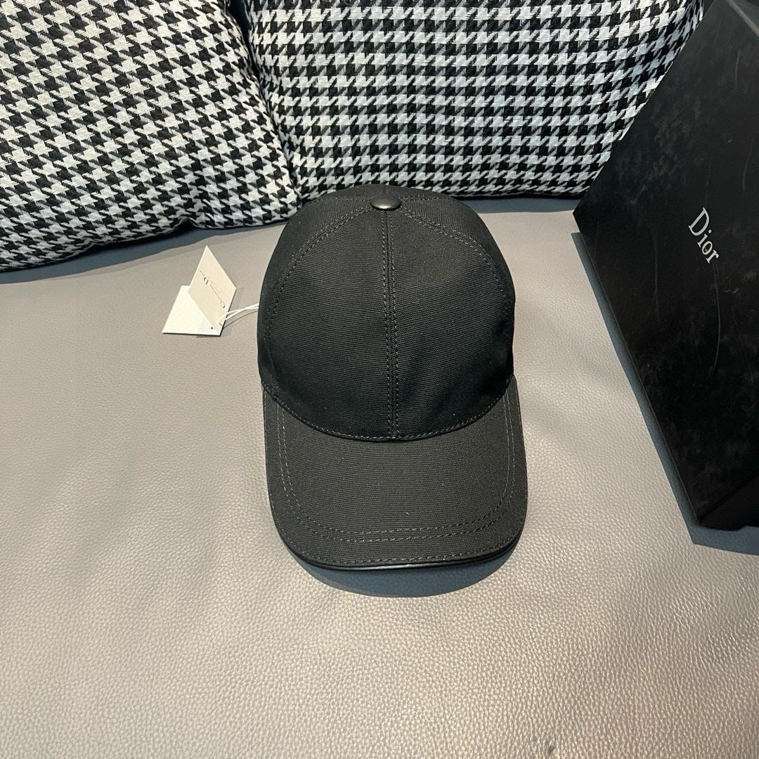 Black Dior cap with button-top crown and curved brim, no logo visible