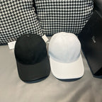 Dior caps pair: black and white curved-brim baseball caps on display.