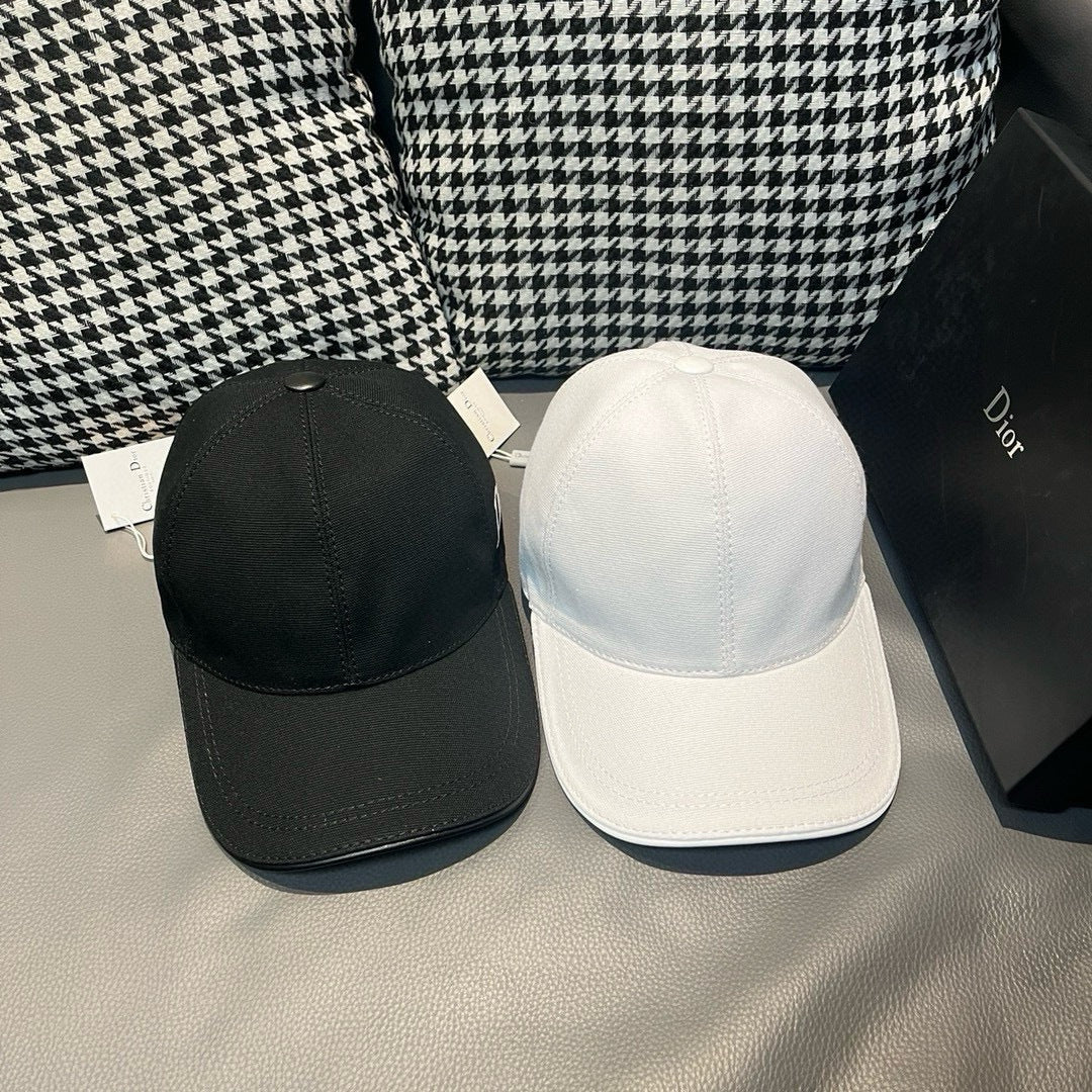 Dior caps pair: black and white curved-brim baseball caps on display.