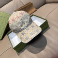 Gucci GG-pattern baseball cap, beige base with multicolor logo motifs and curved brim.