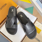 Louis Vuitton slide sandals in dark gray with logo on the footbed and wide strap.