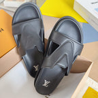 Louis Vuitton slide sandals in dark gray with textured strap detail and LV logo.
