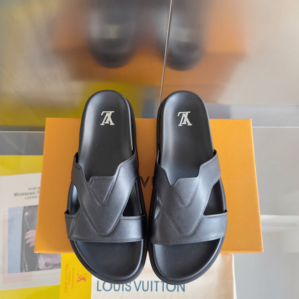 Louis Vuitton slide sandals in dark gray showing two uppers with LV logo on top.
