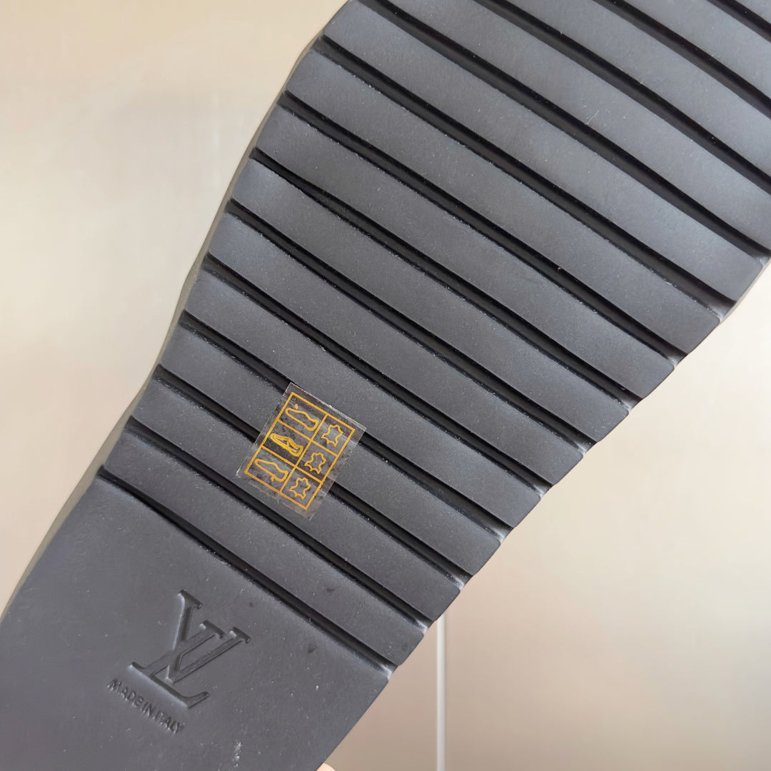 Louis Vuitton slide sandal outsole with tread pattern and LV monogram logo.