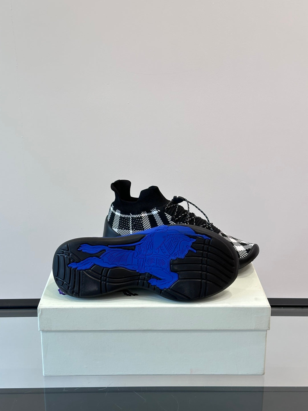Burberry sneakers outsole view with bold blue tread and black check upper
