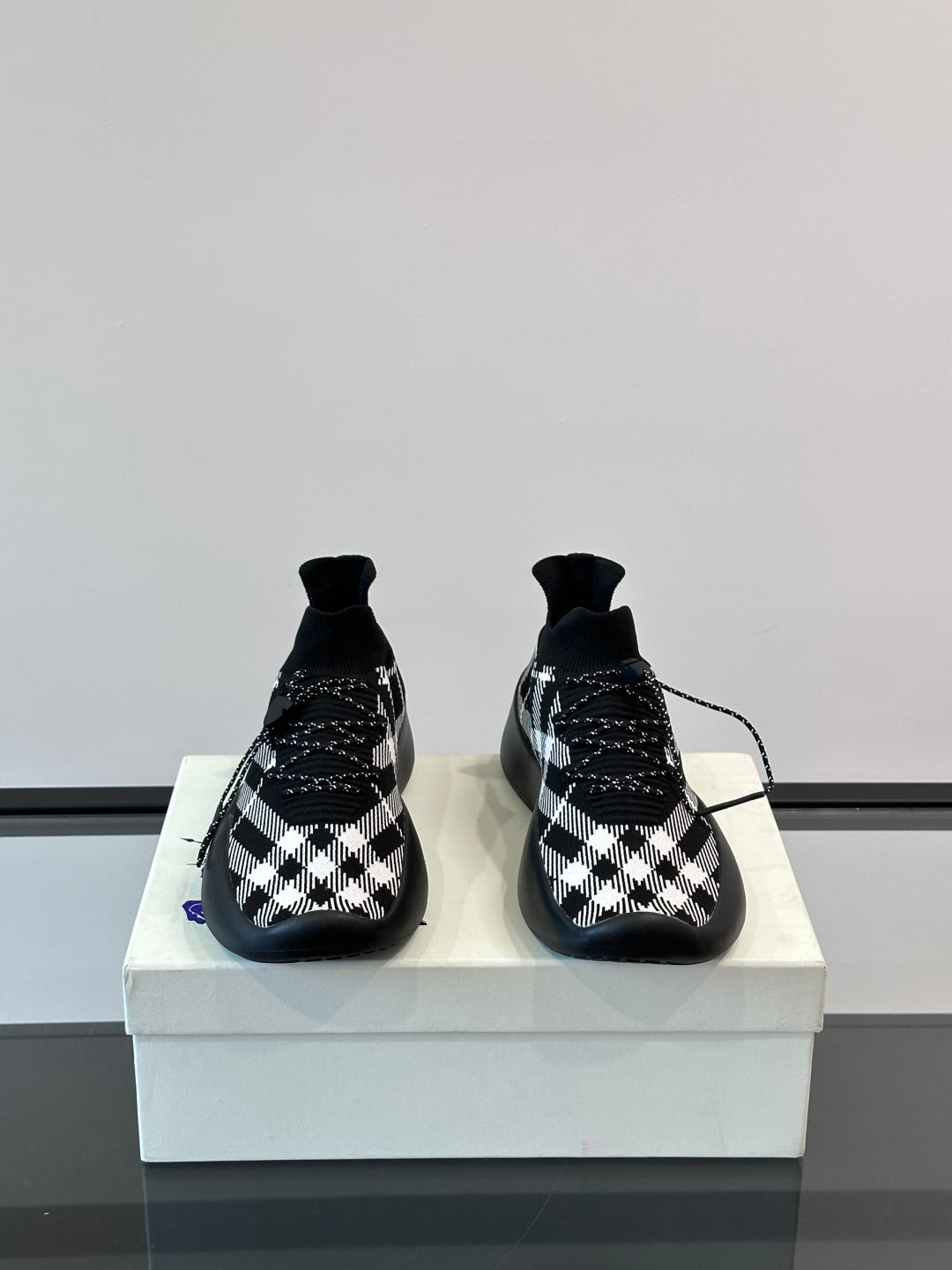 Burberry sneakers pair with black-and-white check pattern and blue sole accents
