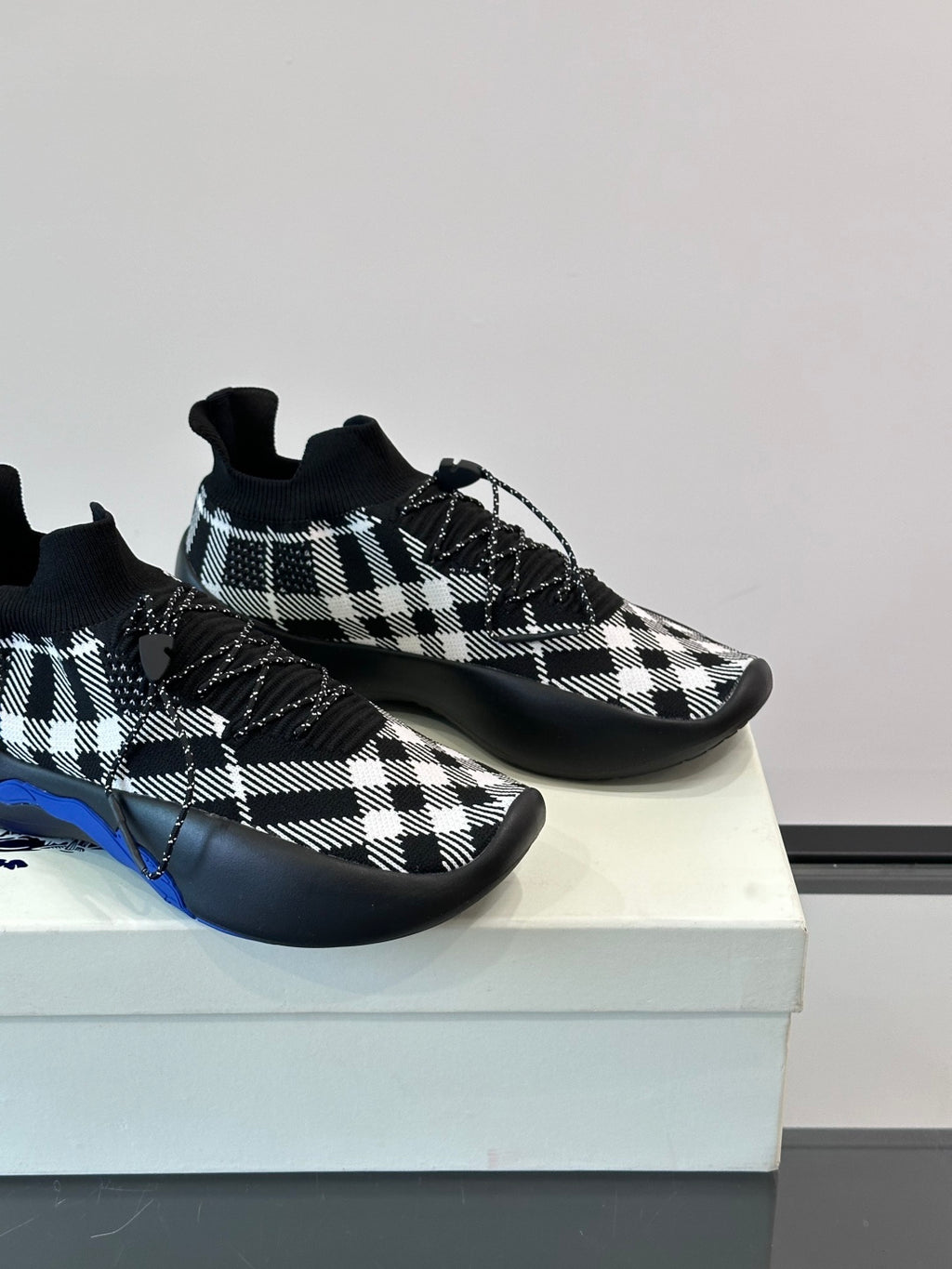 Burberry sneakers close-up showing black-and-white check upper and blue sole edge