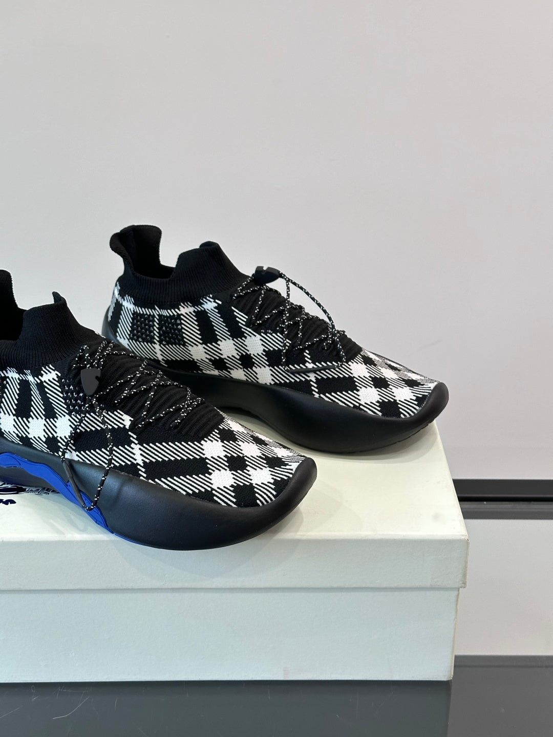 Burberry sneakers close-up showing black-and-white check upper and blue sole edge