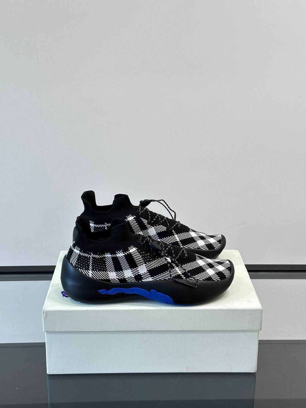 Burberry sneakers with black-and-white check knit upper and blue accent sole