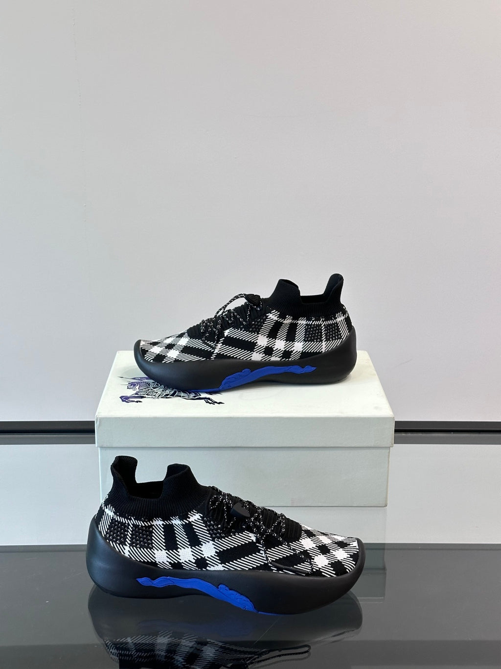 Burberry sneakers with black-and-white check upper and blue trim along sole