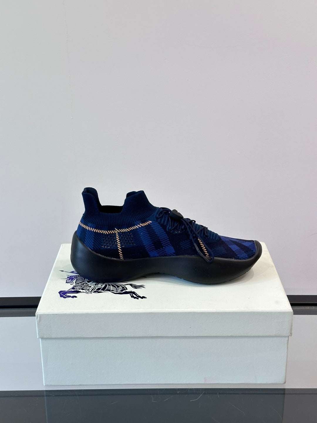 Navy plaid slip-on sneaker with elastic laces, pull-tab heel, and black sole with blue trim
