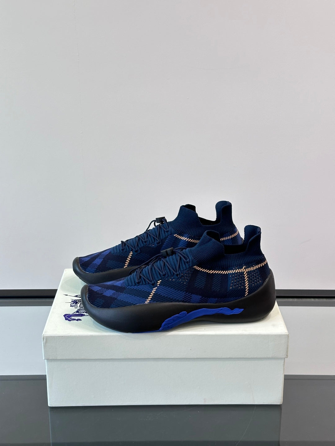 Blue plaid slip-on sneaker with elastic lace detail and black outsole with blue accent