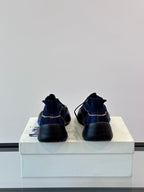 Back view of blue plaid sneakers with pull-tab heel and black rubber sole
