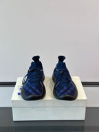 Pair of dark blue plaid sneakers with pull-tab collar, laces, and blue-trimmed sole