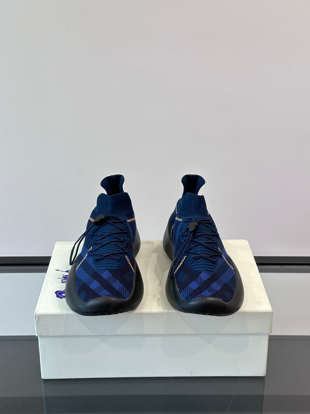 Pair of dark blue plaid sneakers with pull-tab collar, laces, and blue-trimmed sole