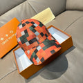 Baseball cap in orange, green, black, and white plaid with curved brim
