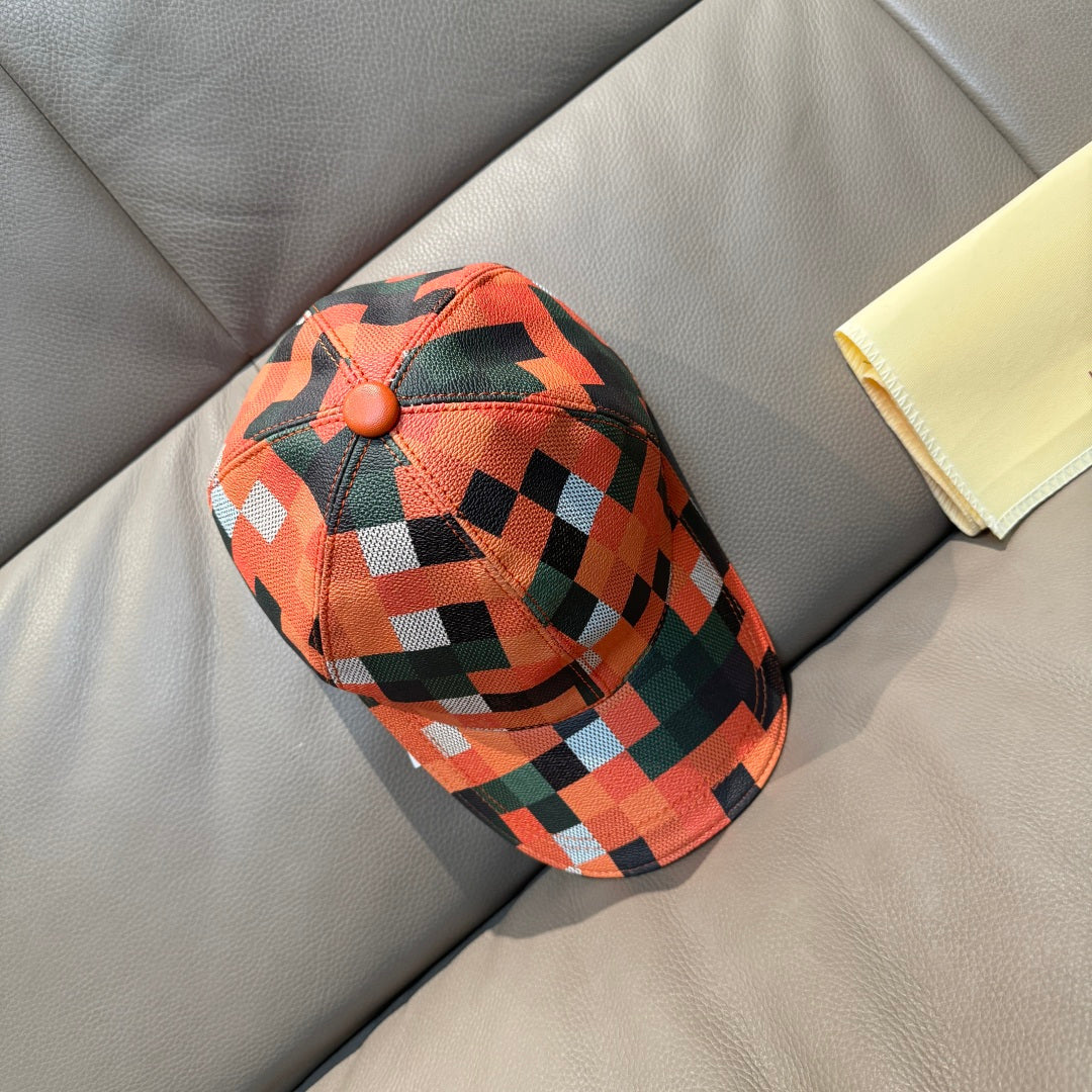 Plaid baseball cap in orange, green, black, and white with button on crown