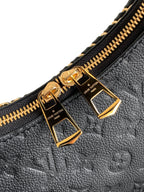 Louis Vuitton black monogram bag close-up of gold zipper pulls and hardware