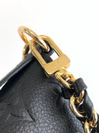 Louis Vuitton black leather bag close-up of gold clasp with embossed logo