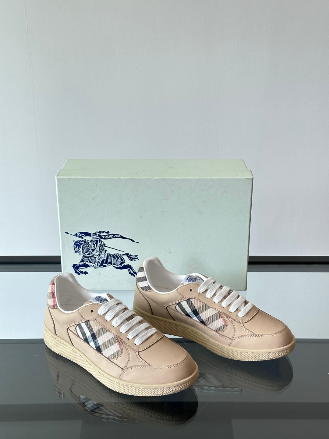 Beige low-top sneakers with white laces and Burberry check stripes on vamps