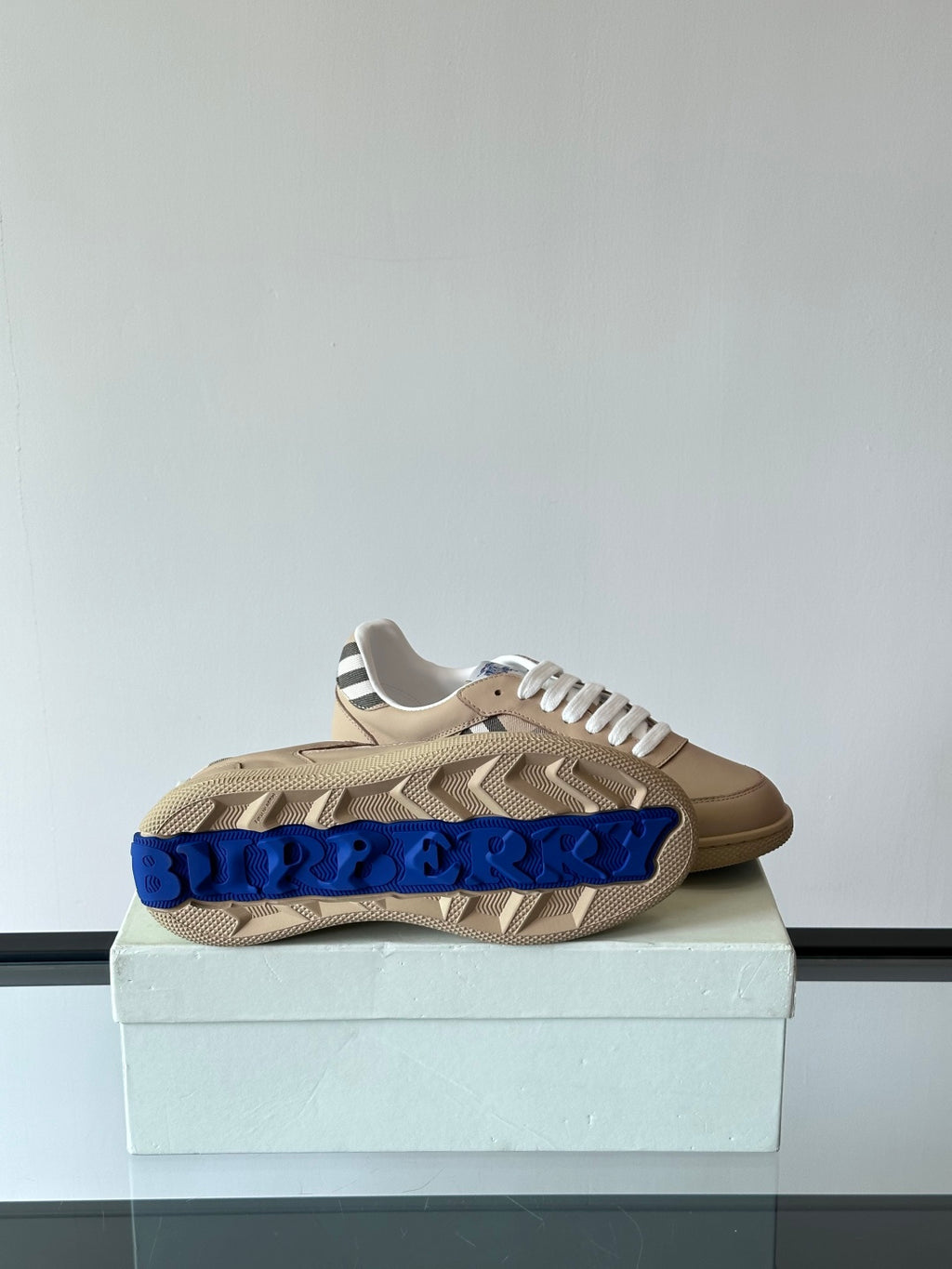Beige low-top sneakers, white laces, Burberry check band on front