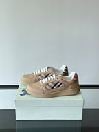 Beige low-top sneakers with white laces and Burberry check strap across sides