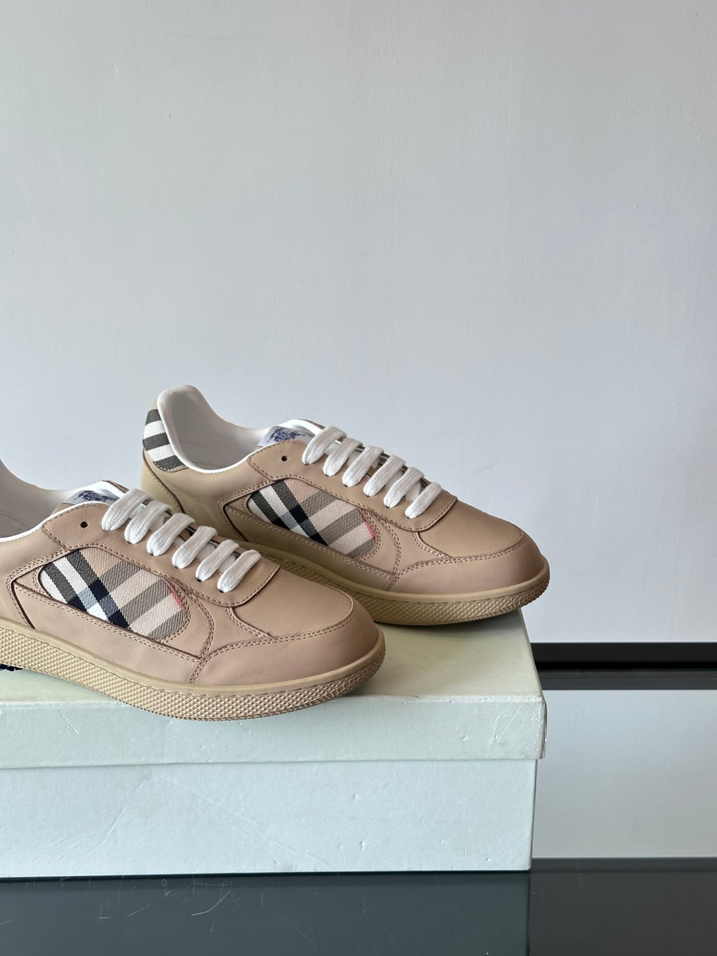 Beige low-top sneakers side view, white laces, Burberry check stripe on each shoe