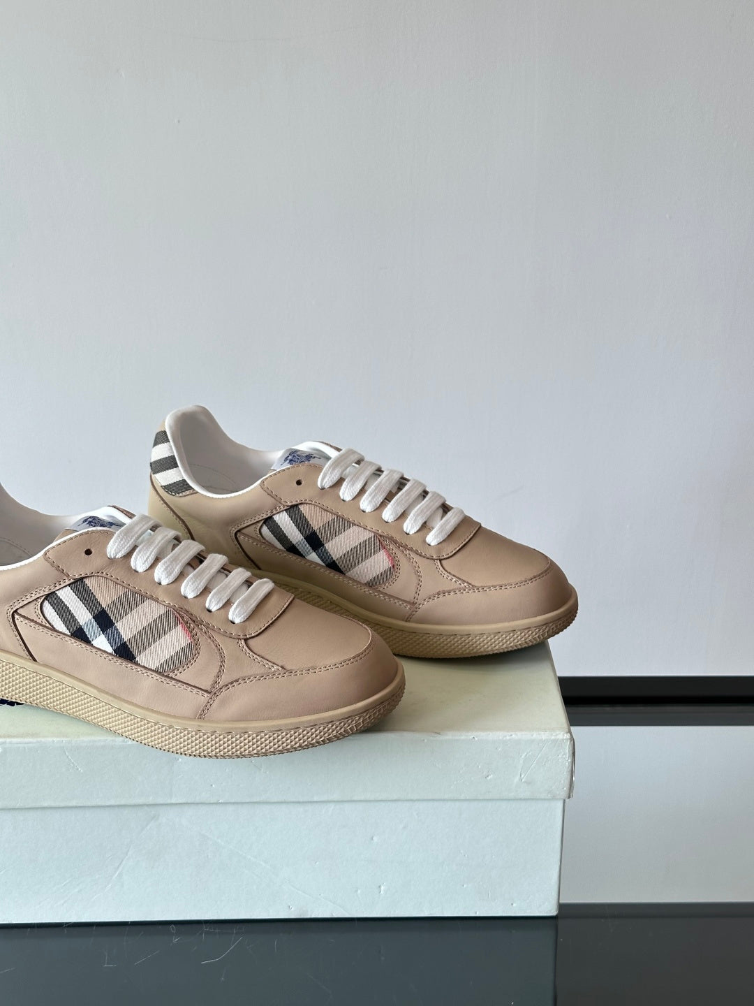 Beige low-top sneakers side view, white laces, Burberry check stripe on each shoe