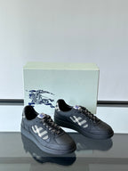 Pair of black low-top sneakers with plaid panel and black braided lace detail