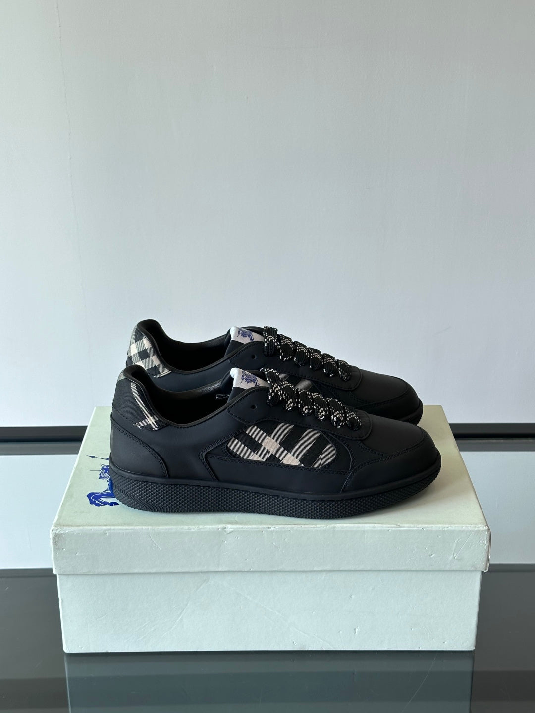 Black low-top sneakers with plaid panel and black lace-up design