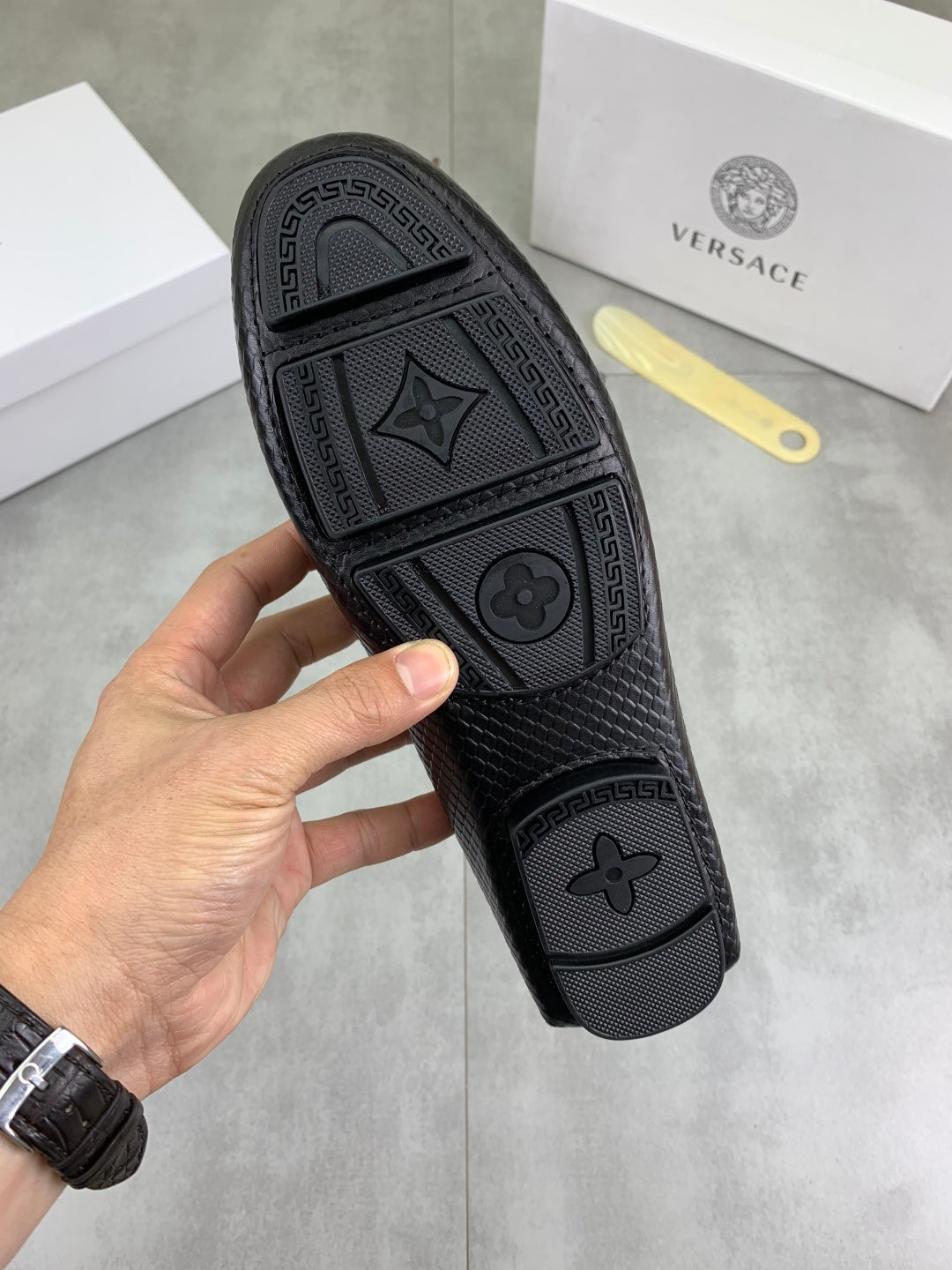 Black loafer rubber sole with textured pattern, held bottom-up