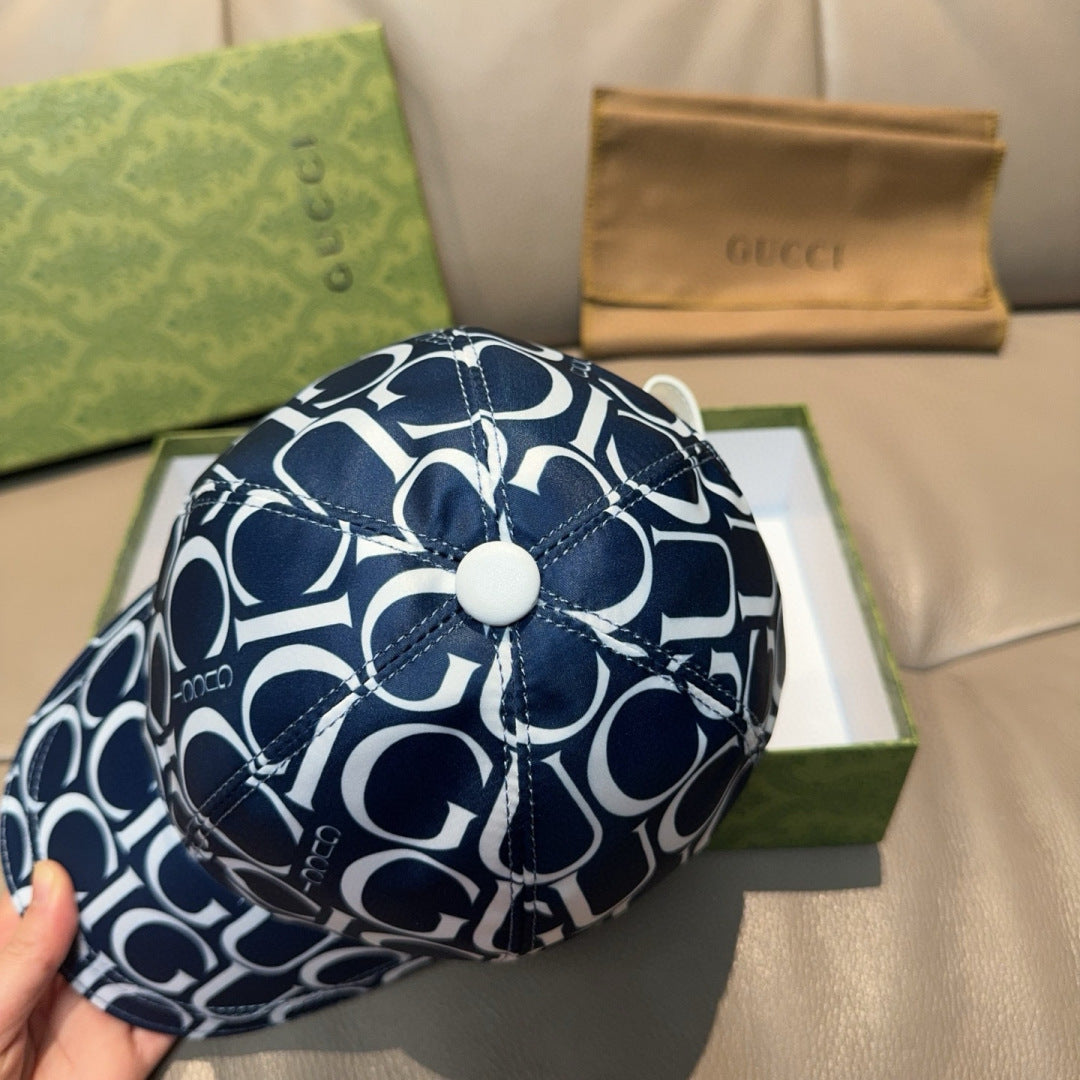 Gucci cap front in navy and white GG monogram, round white button on crown.