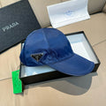 Blue satin baseball cap with Prada triangular logo patch on front.