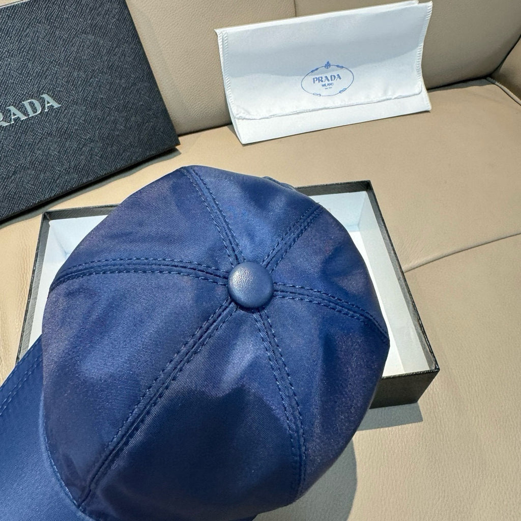Blue satin baseball cap close-up of top button and seam lines.