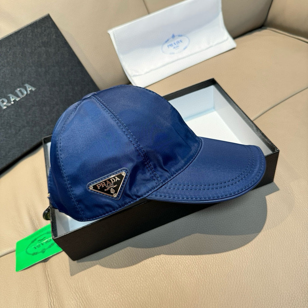 Blue satin baseball cap with stitched brim and triangular Prada logo patch.