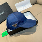 Blue satin baseball cap with stitched brim and triangular Prada logo patch.