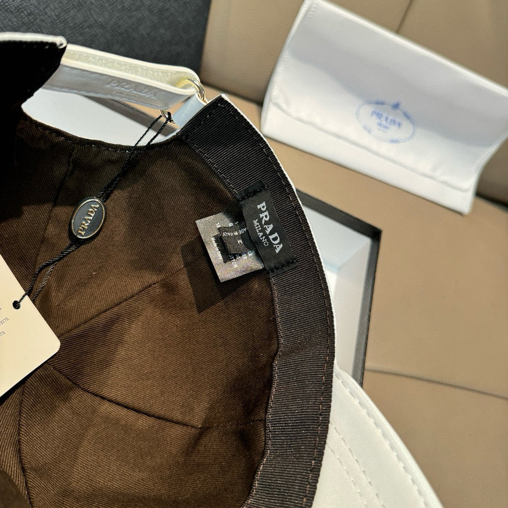 Prada cap in dark brown fabric with black strap and logo patch