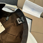 Prada cap in dark brown fabric with black strap and logo patch