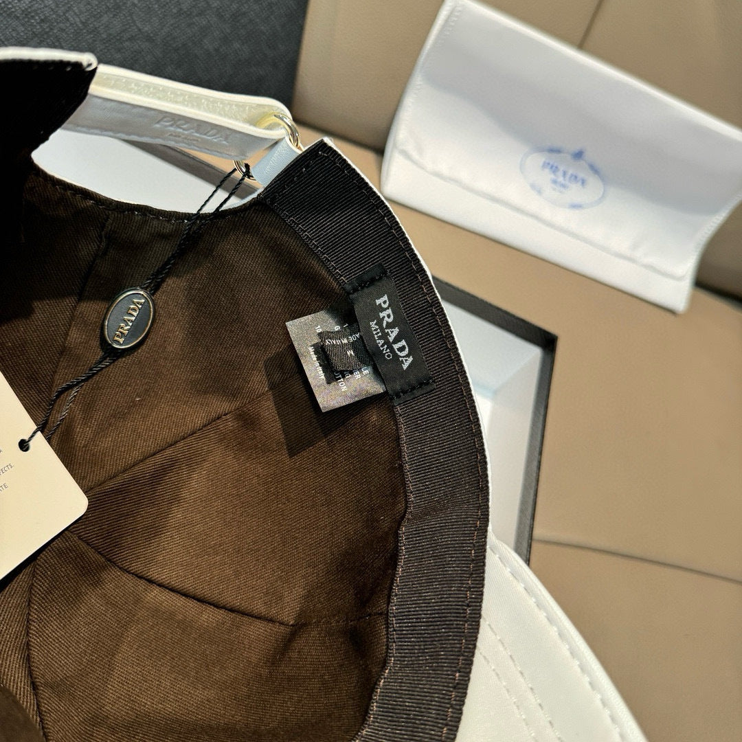 Prada cap in dark brown fabric with black strap and logo patch