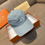 Louis Vuitton denim baseball cap in light blue with embroidered LV logo on front.