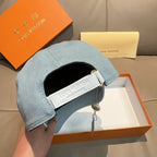 Louis Vuitton denim baseball cap in light blue with adjustable white strap near opening.