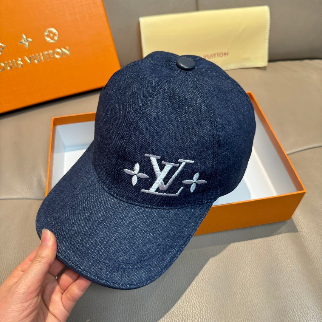 Louis Vuitton denim cap, dark blue denim with LV monogram flower logo; held in hand