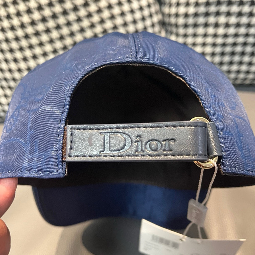 Dior cap with black lining and Dior-printed leather strap on adjustable back.