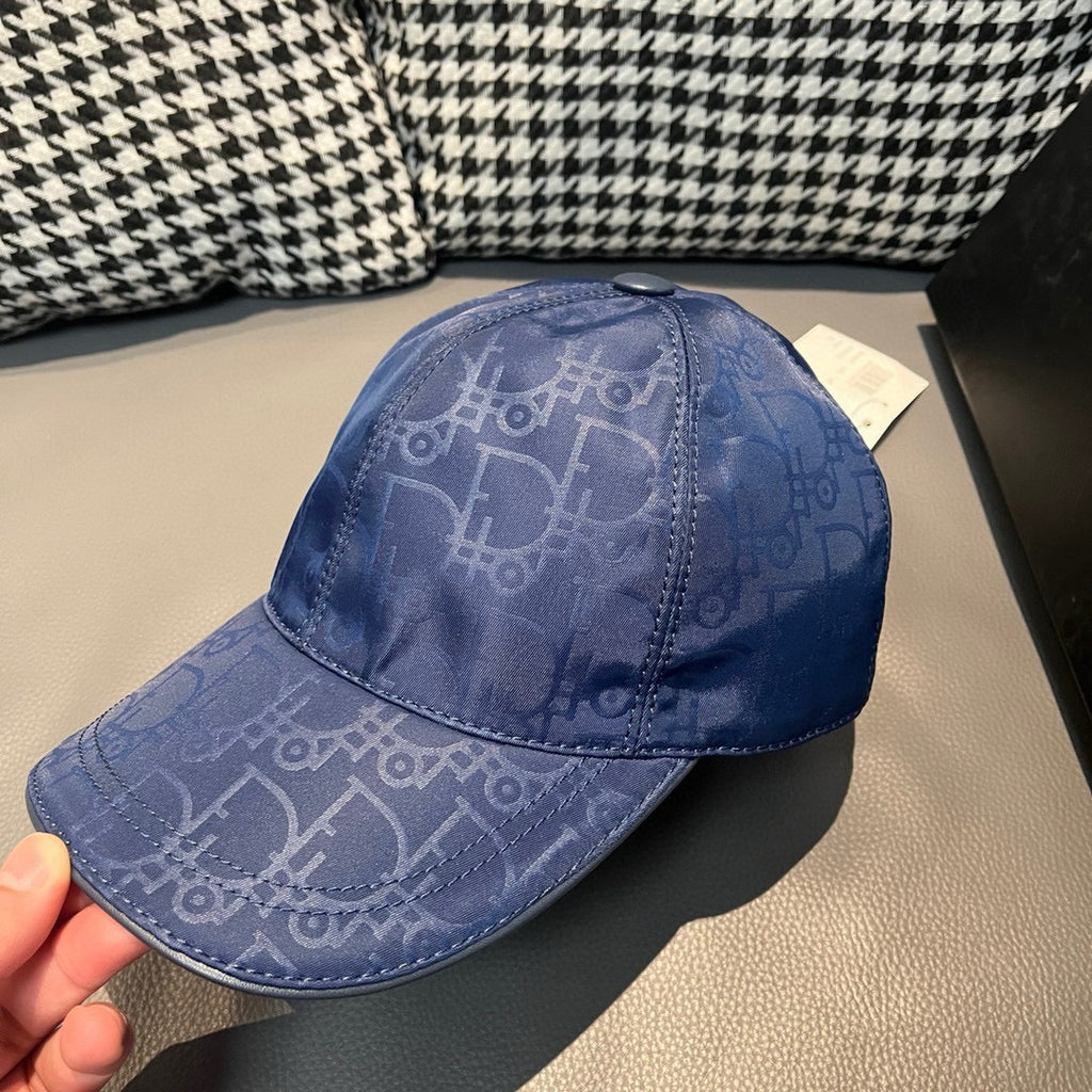 Dior cap in blue with monogram logo print, curved brim, and top button detail.