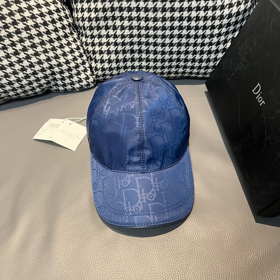 Dior cap in blue with subtle monogram pattern and metal button on top.
