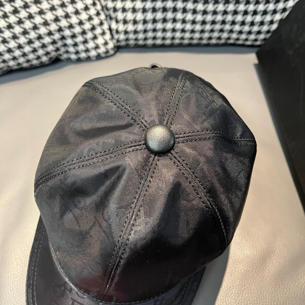 Dior cap close-up with round button crown and monogram print on dark fabric
