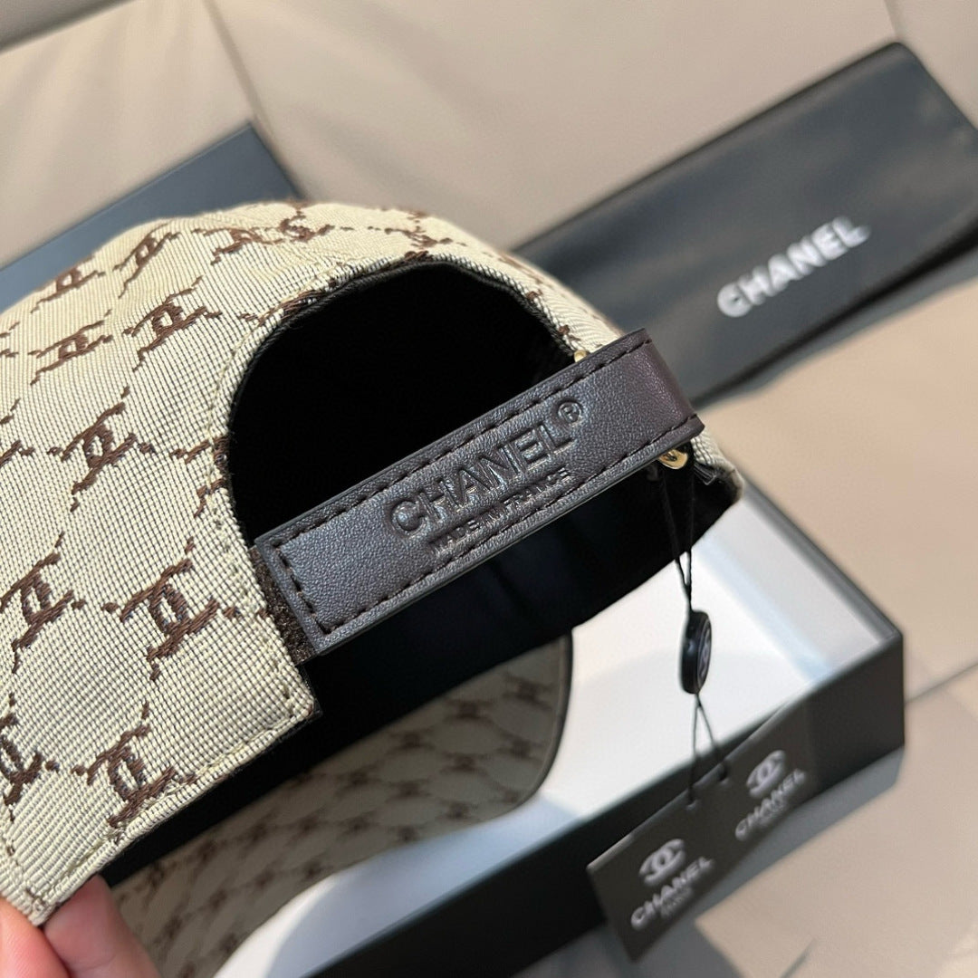 Chanel cap close-up: beige monogram panel with Chanel-branded dark strap trim