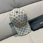 Chanel baseball cap in beige monogram canvas with dark button and curved brim, side view