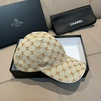 Beige monogram baseball cap with curved brim and top button; side view