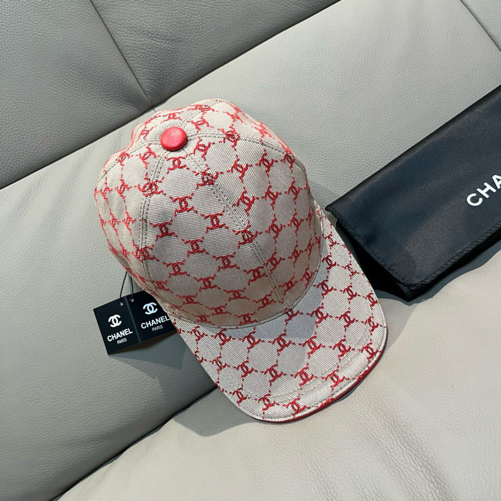 Logo baseball cap with curved brim, red trim, and red button on cream fabric